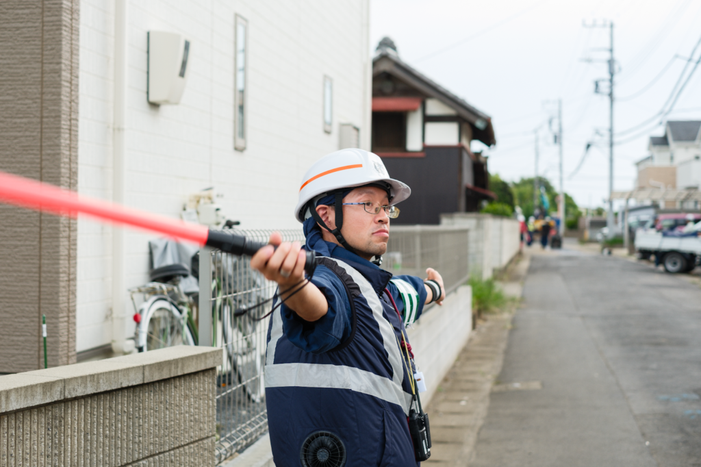 工事現場で歩行者の安全を確保するため交通誘導を行うガードマン